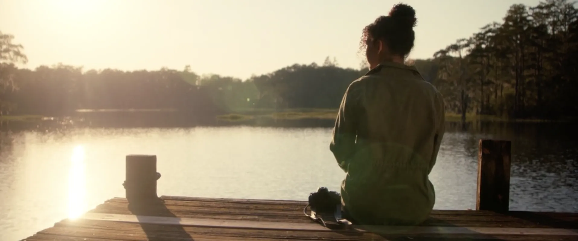 Afterlife still: a woman on a dock at sunset