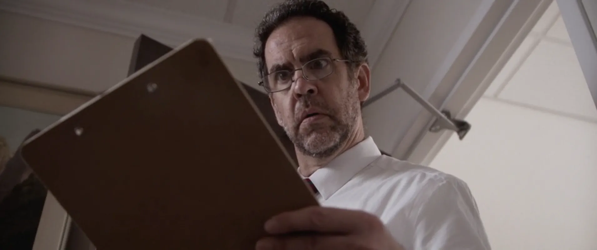 Afterlife still: a man with a clipboard, seen from below