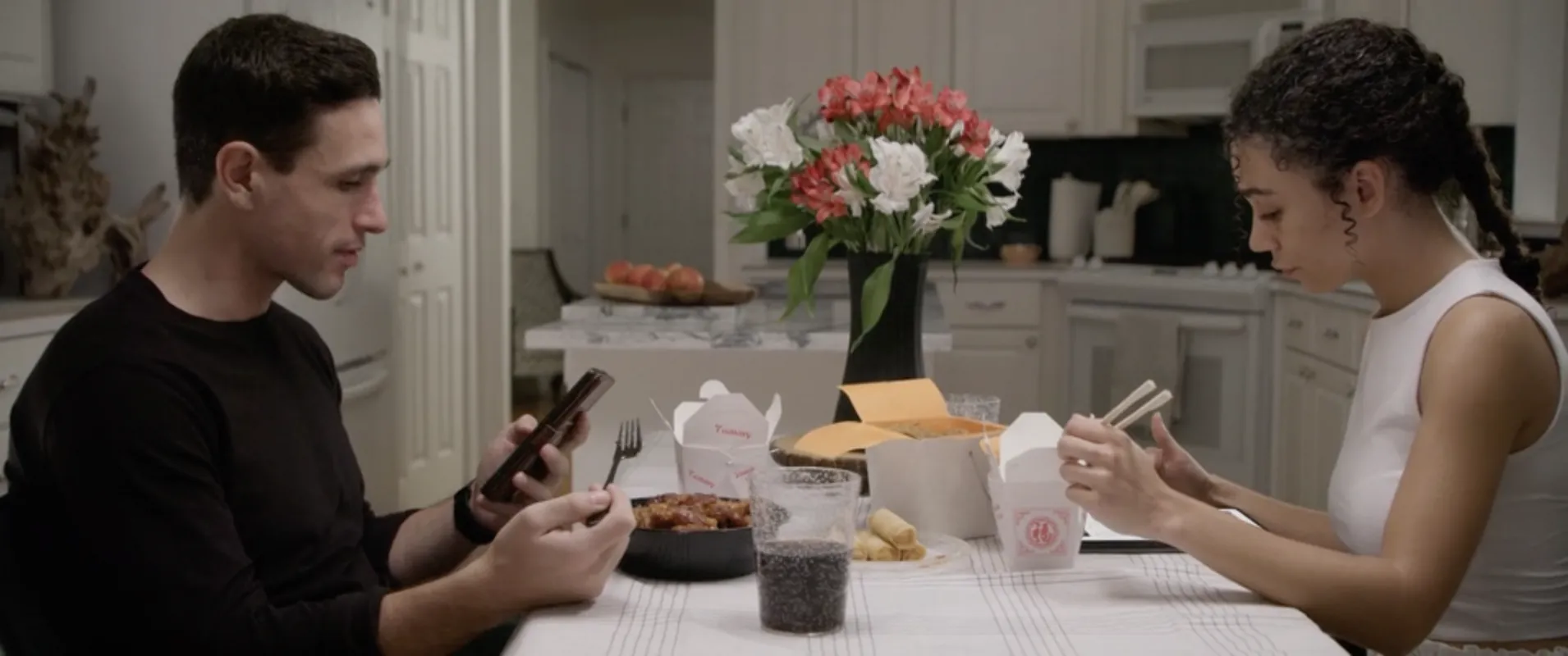 Afterlife still: two people eating takeout at a kitchen table
