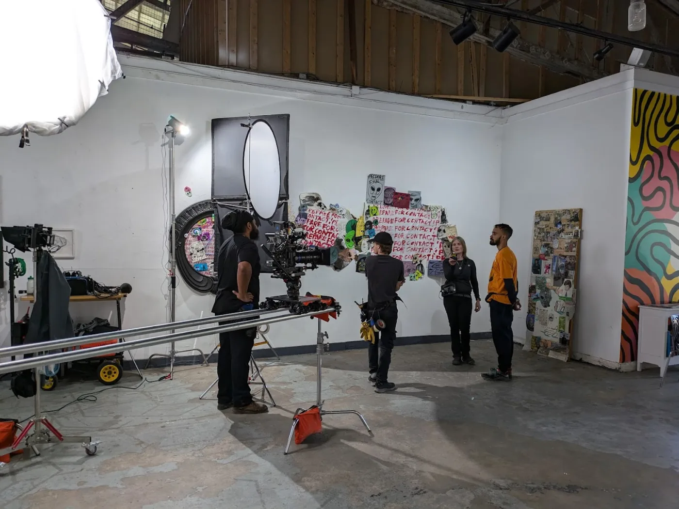 Camera and dolly track in a studio hung with paintings