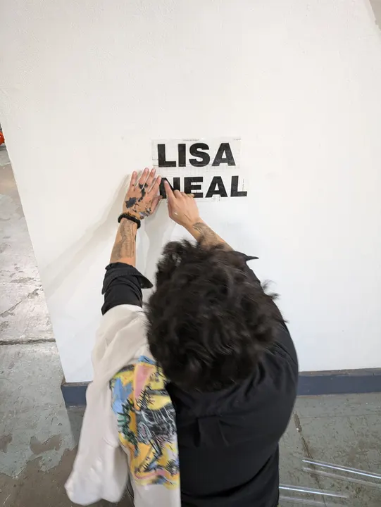 Hand lettering going up on a gallery wall