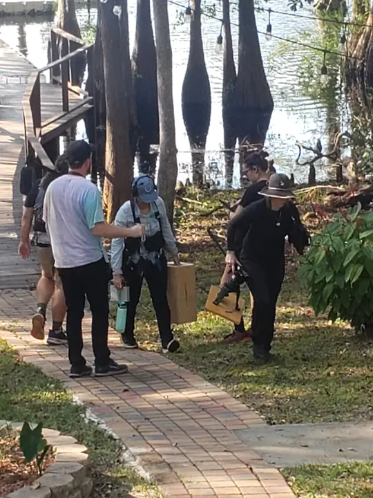 Crew carrying gear down a brick path