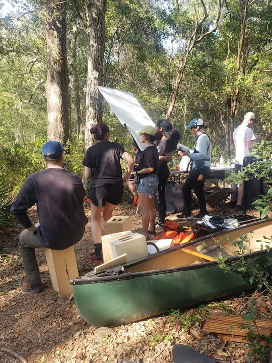 Crew and a green canoe in the woods on the Afterlife shoot